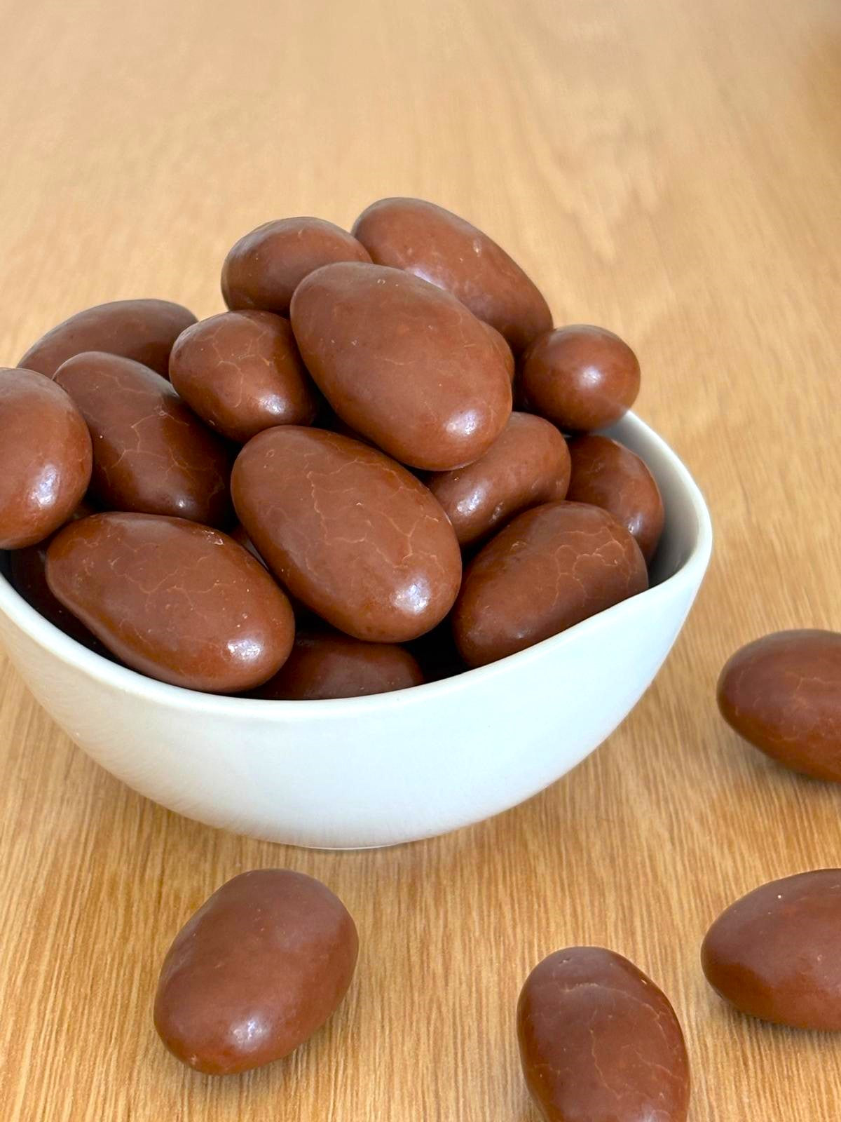 Illustration d'amandes grillées enrobées de chocolat au lait entouré d'amandes grillées
